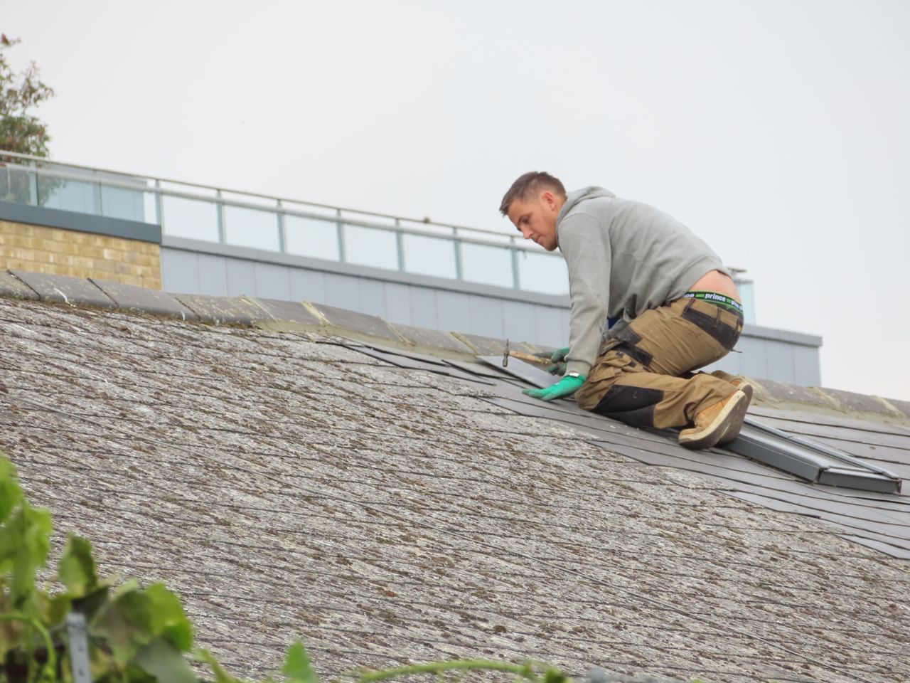 The Art of Drawing Readers In: Your attractive post title goes here Construction worker installing shingles on a rooftop. Outdoor building maintenance.